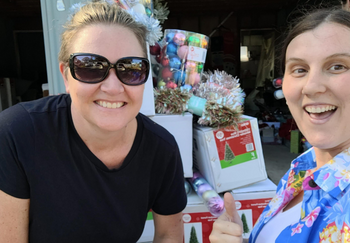 Female volunteers from a Lismore grasroots organisation distributing Christmas trees and decorations to flood-affected locals.