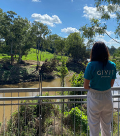 GIVIT staff member looking at flood waters