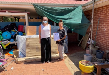 A female staff member from WA Department of Communities with a lady (Ada) who is hollding a voucher from GIVIT