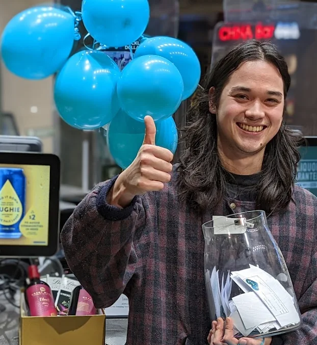 Dan's worker smiling whilst holding donations for GIVIT