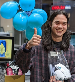 Dan's worker smiling whilst holding donations for GIVIT