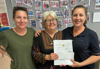 Two ladies with Melinda from Yeronga Community Centre, holding vouchers from GIVIT to buy new household essentials.