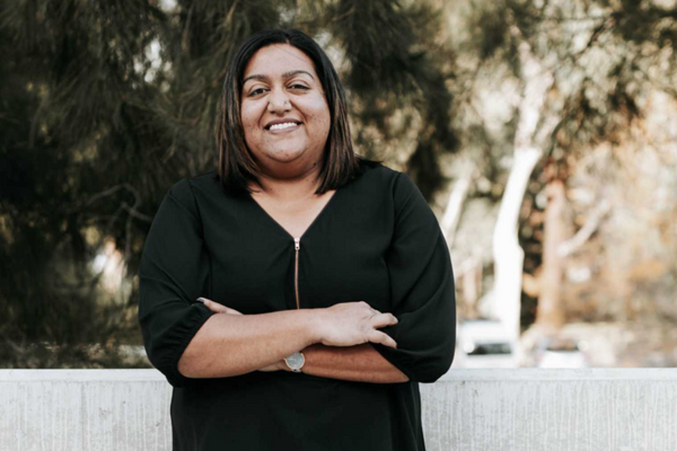 Multicultural Hub Canberra Director Zakia Patel smiling for a photo with her arms crossed